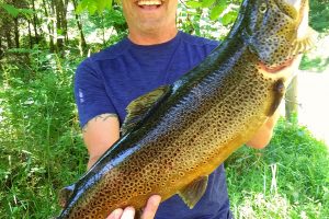 Camper holding a big trout Fancy Gap Cabins and Campground